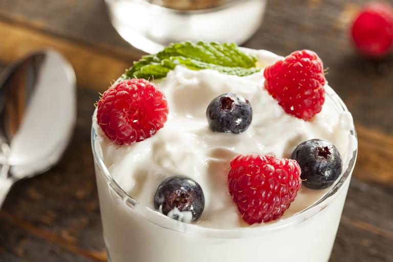 a close-up of a creamy parfait topped with berries
